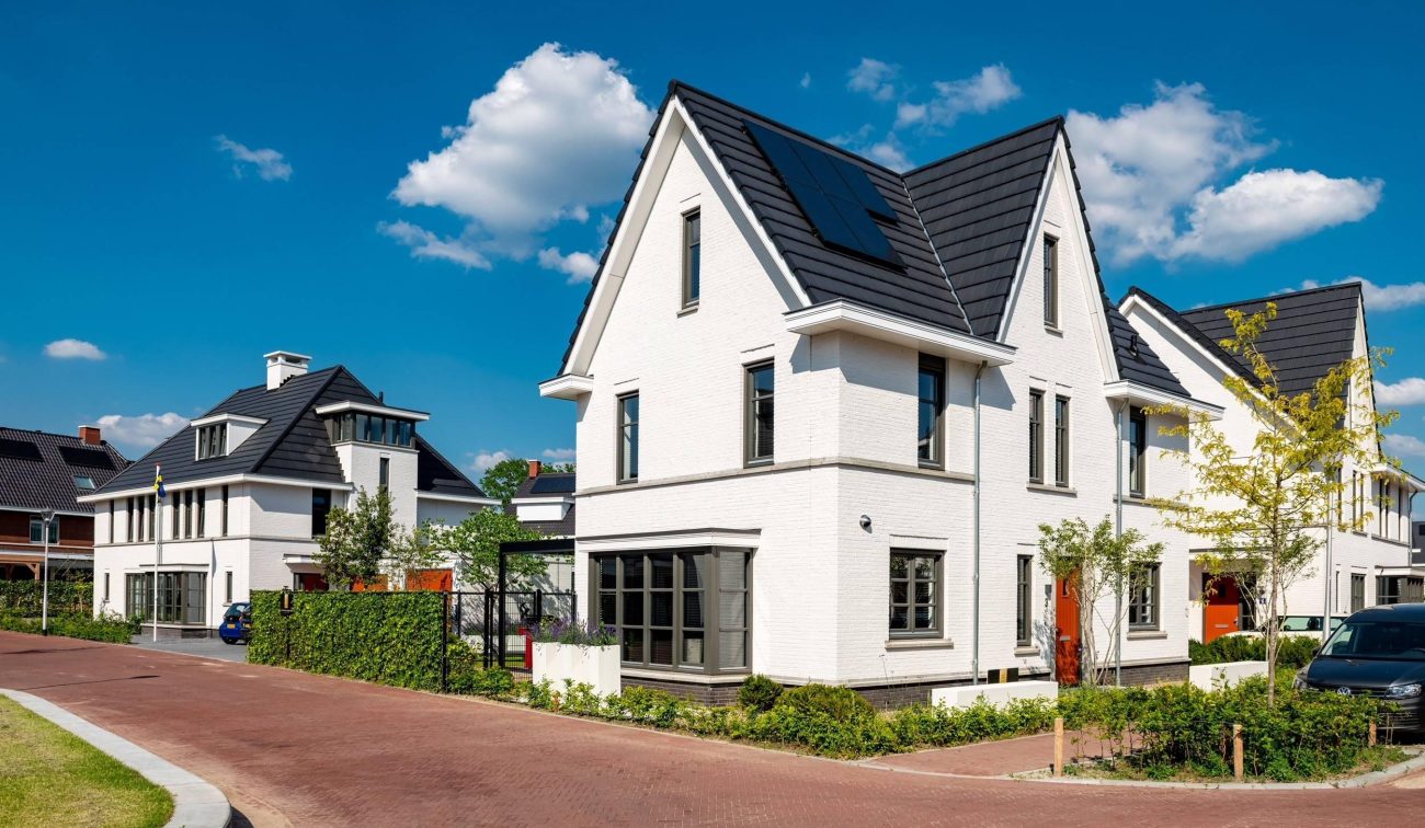 Afgeronde nieuwbouwwoningen in Willemsbuiten Tilburg in karakteristieke jaren 30-stijl, met hoge gevels, erkers en klassieke baksteenarchitectuur in een groene woonwijk.