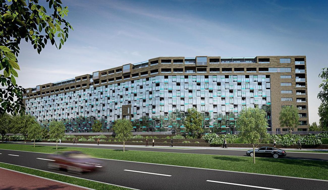 Impressie renovatie en optoppen flatgebouwen Breda: hoge gevel met glas, balkons en groen aan weg