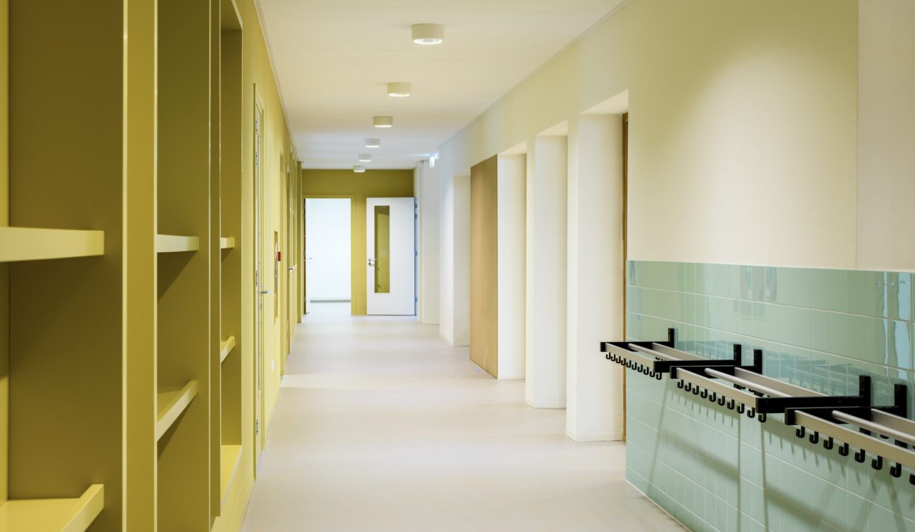 Renovatie OBS De Fakkel Utrecht: lichte schoolgang met mintgroene tegels, kapstokhaken en nissen