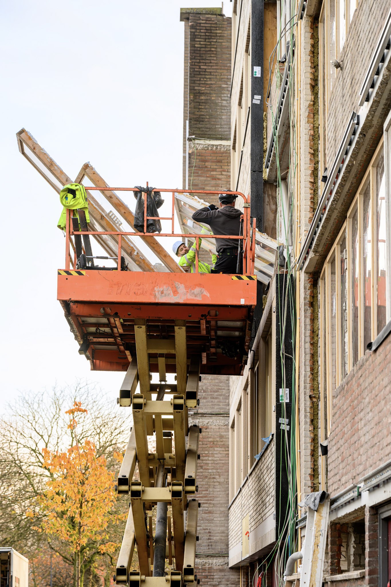 Groot onderhoud Prontoflats Helmond – montage van prefab gevelelementen vanaf een hoogwerker tijdens renovatie.