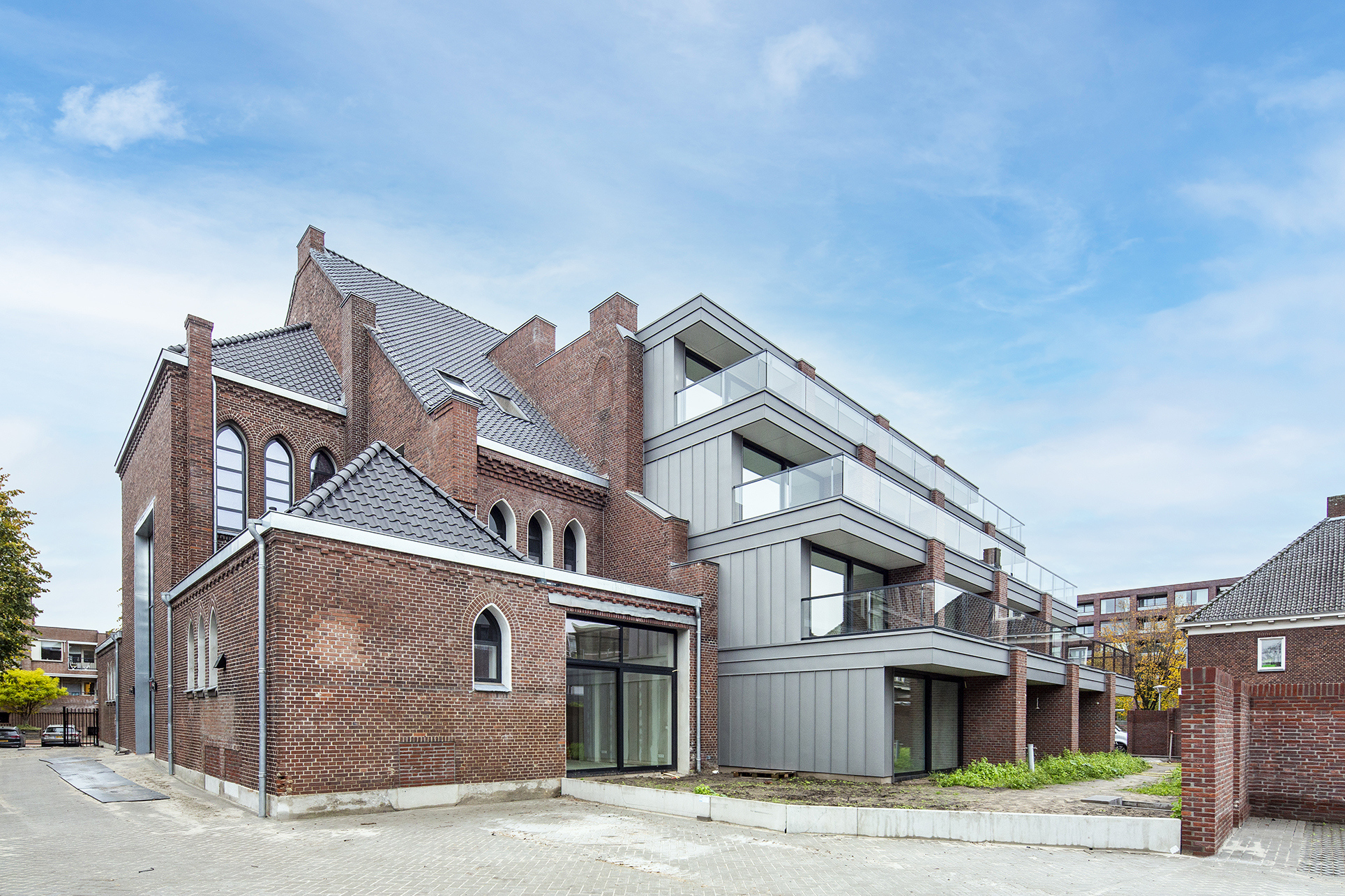 Transformatie van bakstenen kerkgebouw met aangebouwde appartementen en balkons