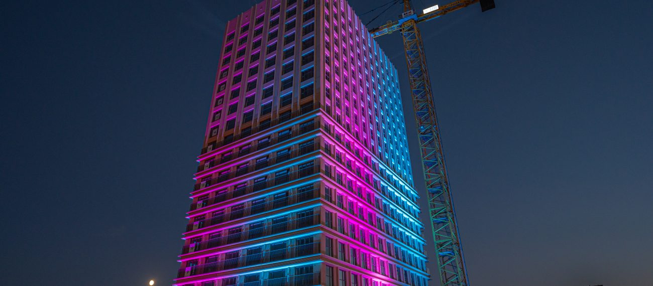 Een gebouw dat blauw en roze licht geeft