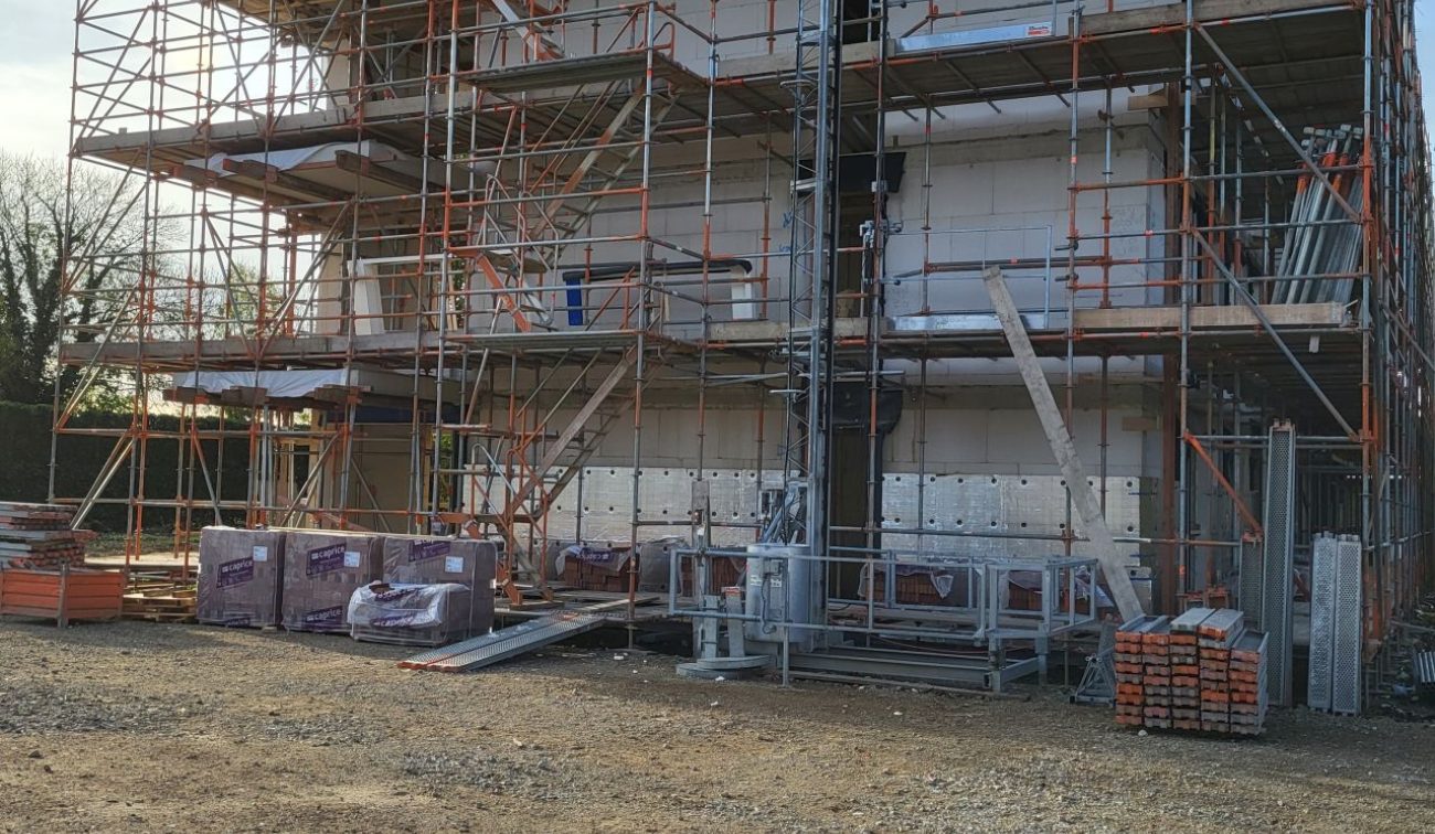 Bouwfase sociale huur Margraten: verdiepingen met steigers, liftmast en bouwmaterialen.