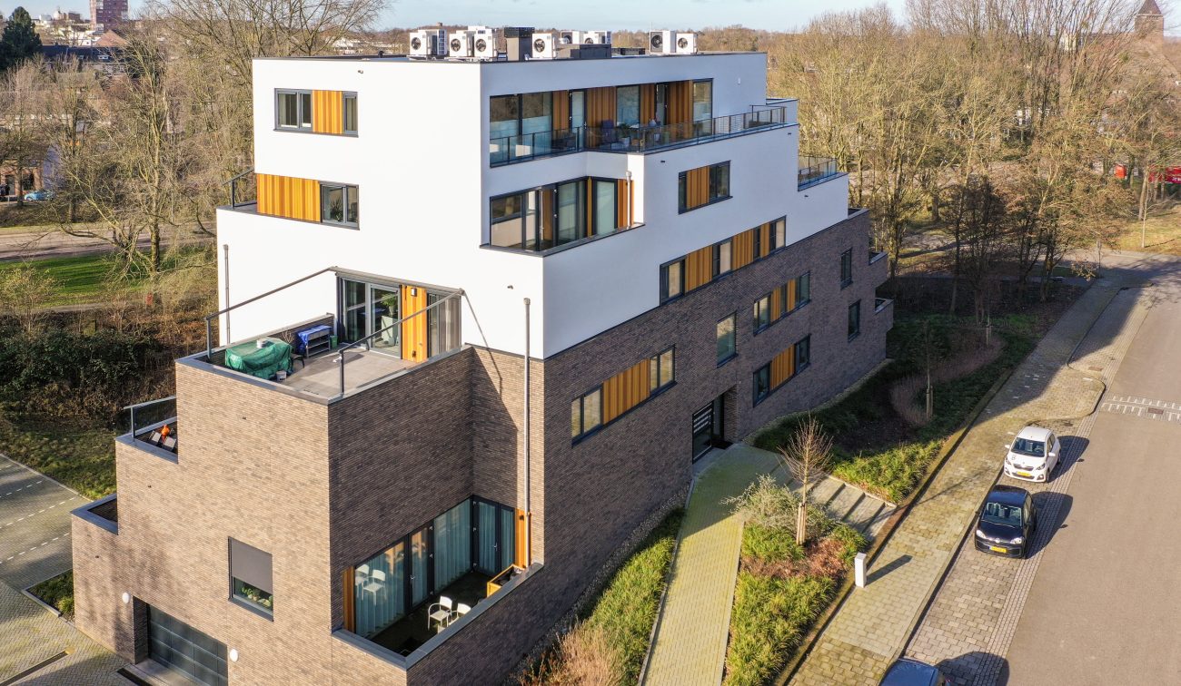 Modern woongebouw met verspringende lagen, houten lamellen en grote dakterrassen — Gebiedsontwikkeling Parkheuvel Heerlen