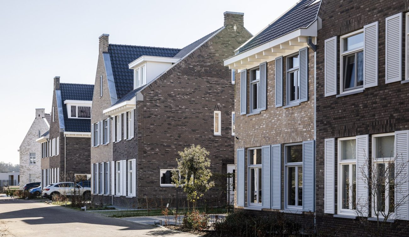 Rijwoningen met bakstenen gevels langs woonstraat in nieuwbouwwijk