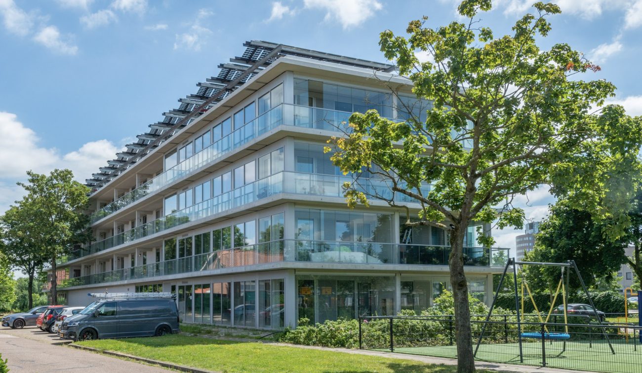 Ander zijaanzicht van het nieuwbouwproject in de Gestelse Buurt in ’s-Hertogenbosch, met zicht op de gevels en buitenruimte van het appartementencomplex.