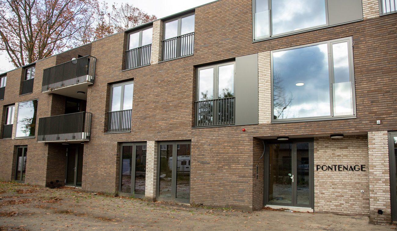 Vooraanzicht van woonzorgcomplex Pontenage in Gemert, een modern gebouw met bakstenen gevel, grote ramen en balkons.