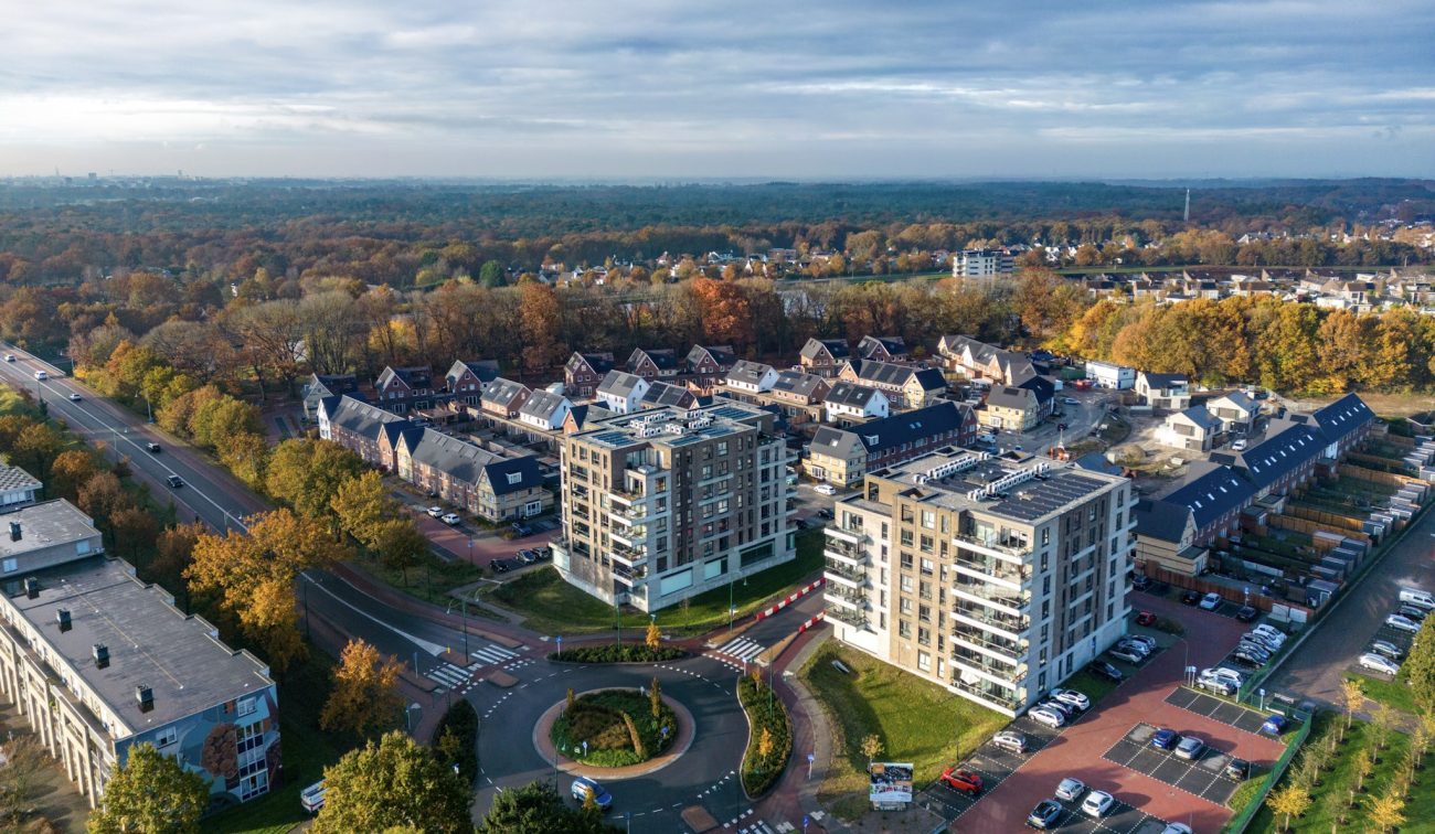 Luchtfoto van het voltooide nieuwbouwproject Wilhelminahaven in Oosterhout, met twee moderne appartemententorens, rijwoningen en groene woonomgeving.