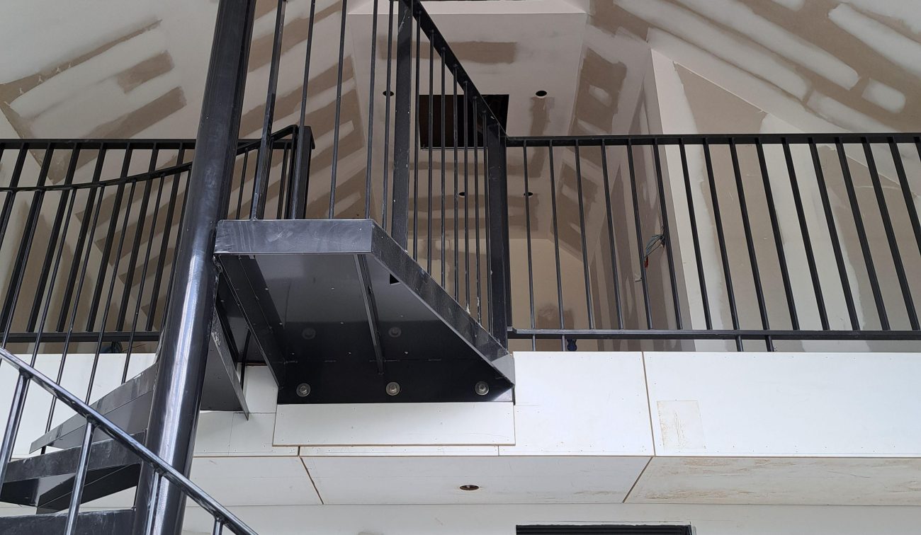 Uitbreiding en renovatie Van der Valk Hotel Wassenaar – interieur in afbouw met stalen spiltrap, vide met zwart metalen balustrade en onafgewerkte gipsplafonds.