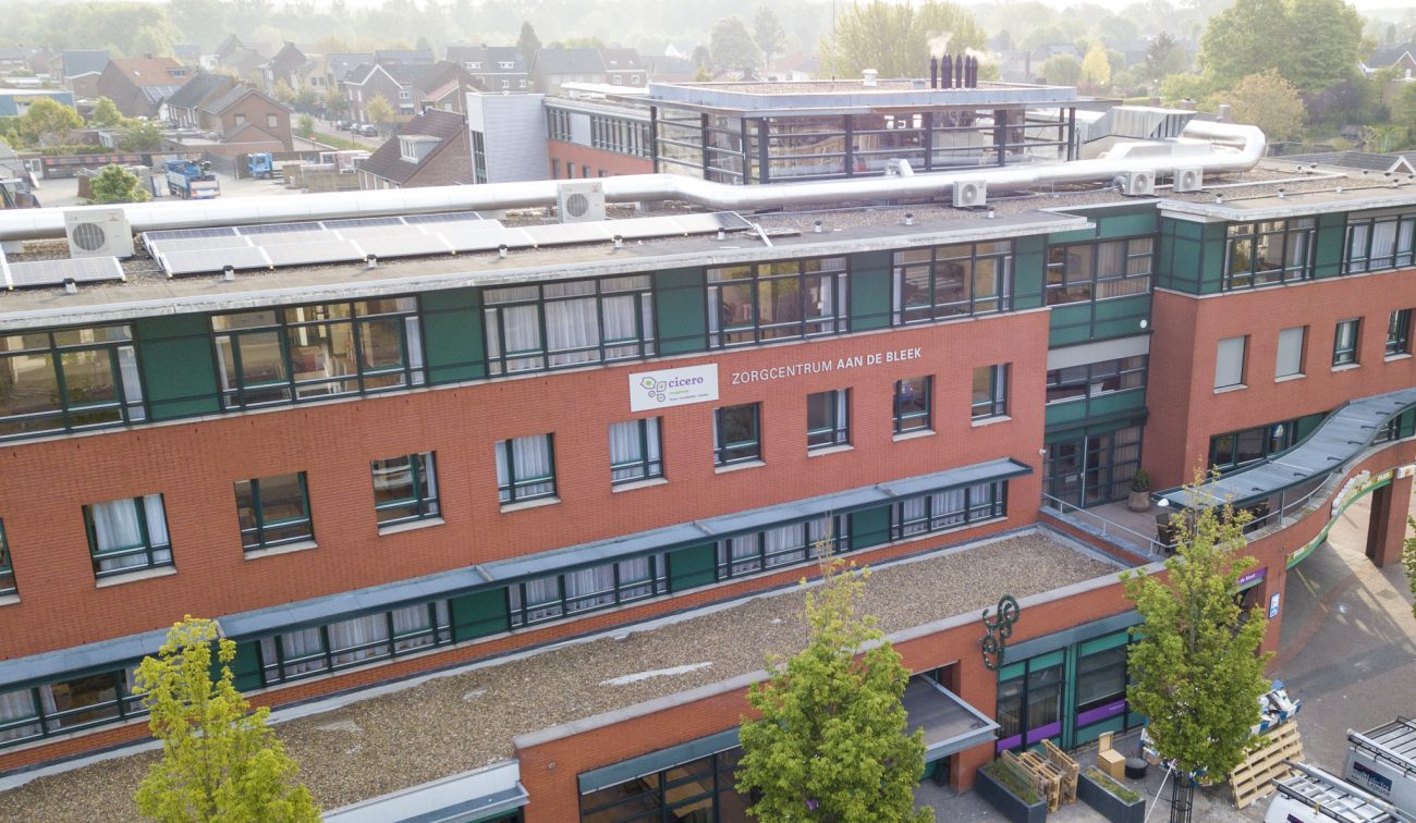 Luchtfoto renovatie zorgcentrum Aan de Bleek Schinveld: rood metselwerk, groene kozijnen, pv-panelen