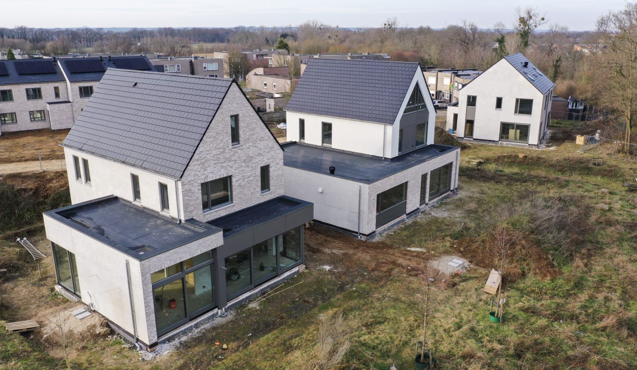 CPO Meerdel Elsloo – vrijstaande nieuwbouwwoningen met grijs metselwerk, zadeldaken en platte aanbouwen met grote glaspuien, erf in aanleg