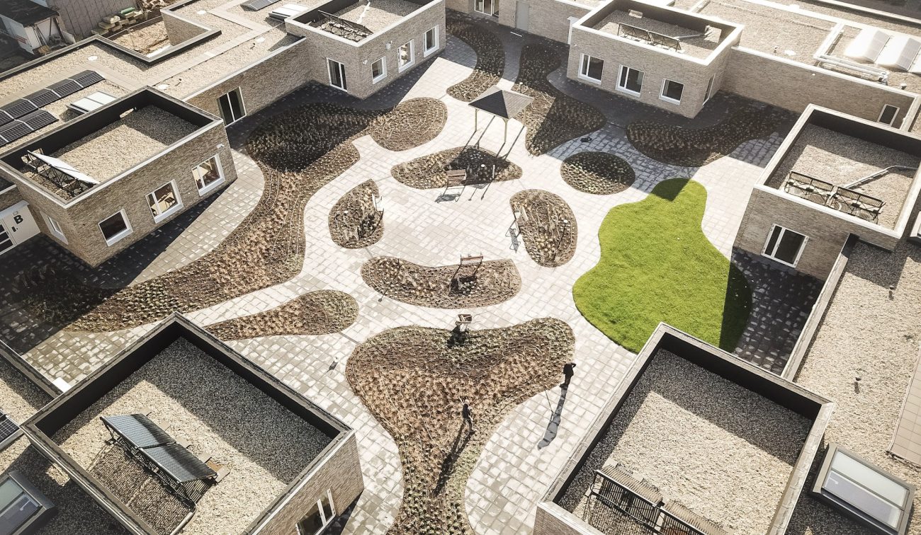 Binnentuin verpleeghuis Panhuys Hulsberg met organische paden, zitplekken en gras.