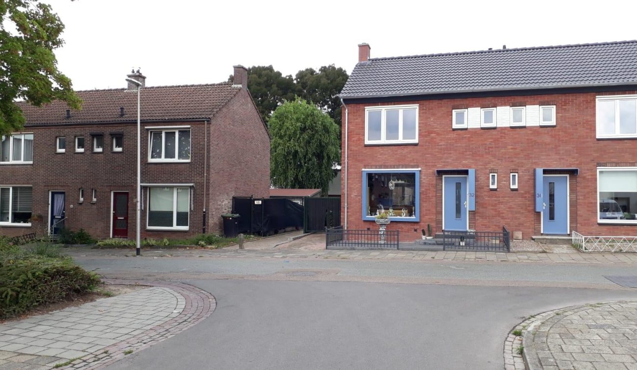 Voorgevels in Heerlen: vernieuwde woning met blauwe deuren naast oorspronkelijke baksteenwoning