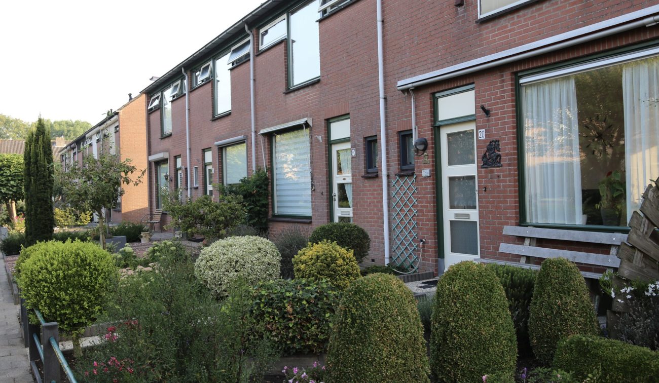 Bloemenwijk Almkerk: rijwoningen in baksteen met groene kozijnen nette voortuinen en heggen verzorgd