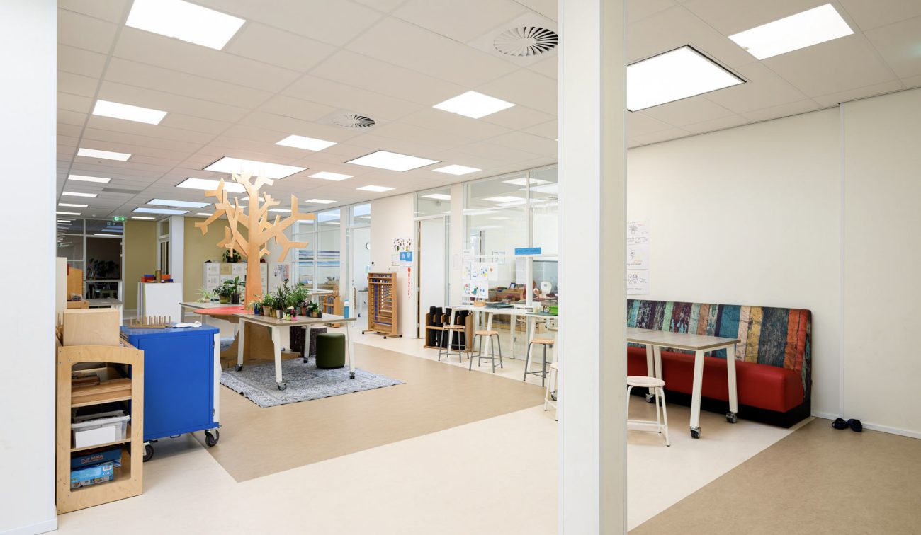 Renovatie Kindcentrum LEF Utrecht – licht en open leerplein met glaswanden, flexibel in te delen werkhoeken en akoestisch plafond voor rust in de onderwijsruimtes.
