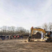 Wethouder gemeente Cuijk verricht symbolische eerste graafhandeling met graafmachine tijdens start bouw Bosrijk Mariëndaal in Velp