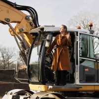 Wethouder gemeente Cuijk op bouwlocatie in graafmachine tijdens start bouw Bosrijk Mariëndaal in Velp