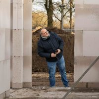 Bezoeker bekijkt de nieuwe woning tussen prefab beton in aanbouw tijdens start bouw Bosrijk Mariëndaal in Velp