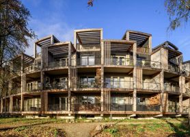 Nieuwbouw ROOT Eindhoven – duurzame ronde appartementen met houten gevels, diepe terrassen en moderne architectuur.