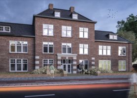 Impressie van de nieuwbouwkazerne in Helmond tijdens de avond, met verlichte gevel en mensen die langs het gebouw lopen.