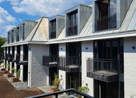 Uitbreiding en renovatie Van der Valk Hotel Wassenaar – binnenhof met hotelkamers, zinken dakkapellen en balkons aan witte gevels, gezien vanaf de galerij.