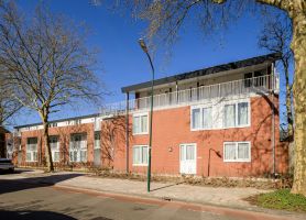 Vooraanzicht van wooncomplet met aanbouw van extra studio's op de bovenste verdieping