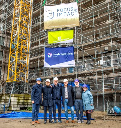 Groep werknemers van Huybregts Relou die geposeerd staan voor een bouwproject