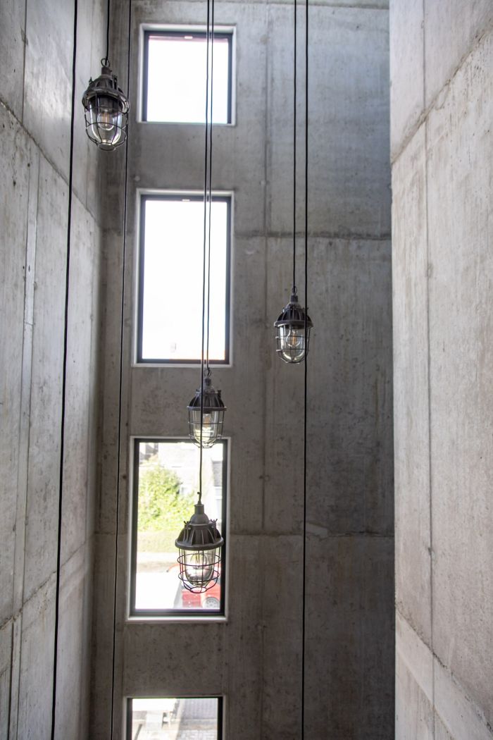 MFA Hart voor Treebeek Brunssum – betonnen lichtschacht met smalle verticale ramen en industriële hanglampen