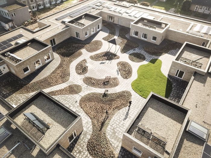 Binnentuin verpleeghuis Panhuys Hulsberg met organische paden, zitplekken en gras.