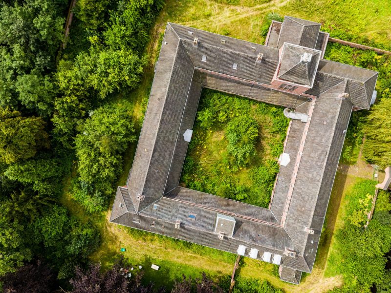 Luchtfoto van het Clarissenklooster omringd door tuin en bos
