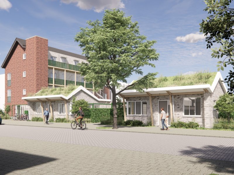 Impressie van het nieuwbouwproject Voetnoodt, met zicht op het appartementencomplex en de bungalows vanuit een andere hoek, omgeven door groen.